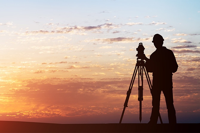 Surveyor against a sunset