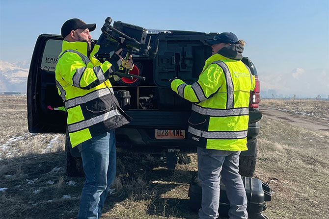 Two surveyors unloading equipment from truck