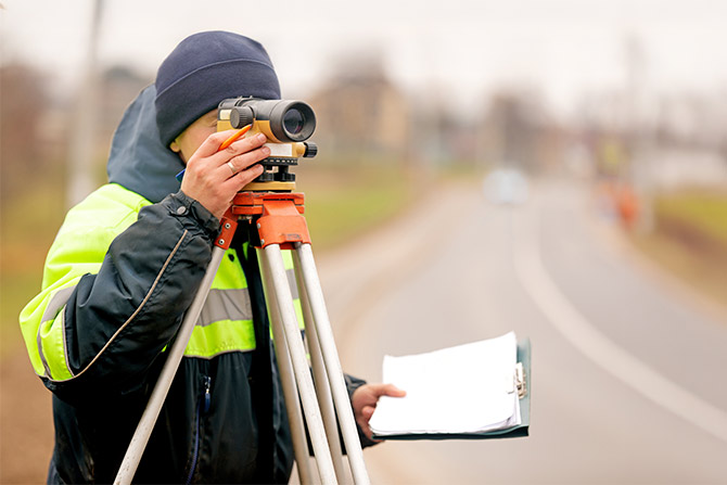 Surveyor at work by road