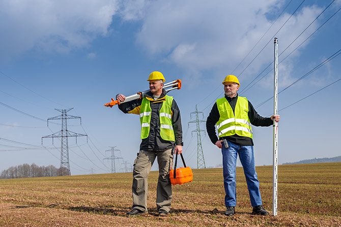 Surveyors out in the field under powerlines